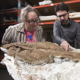 Photo of two people with a fossil