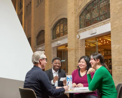 Conversations at ROM four people sitting at a table, having a fun conversation at the Royal Ontario Museum