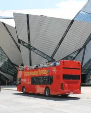 Double-decker bus passing by the Royal Ontario Museum.