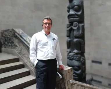 A man posing at the bottom of a stair case. A man posing at the bottom of a stair case.