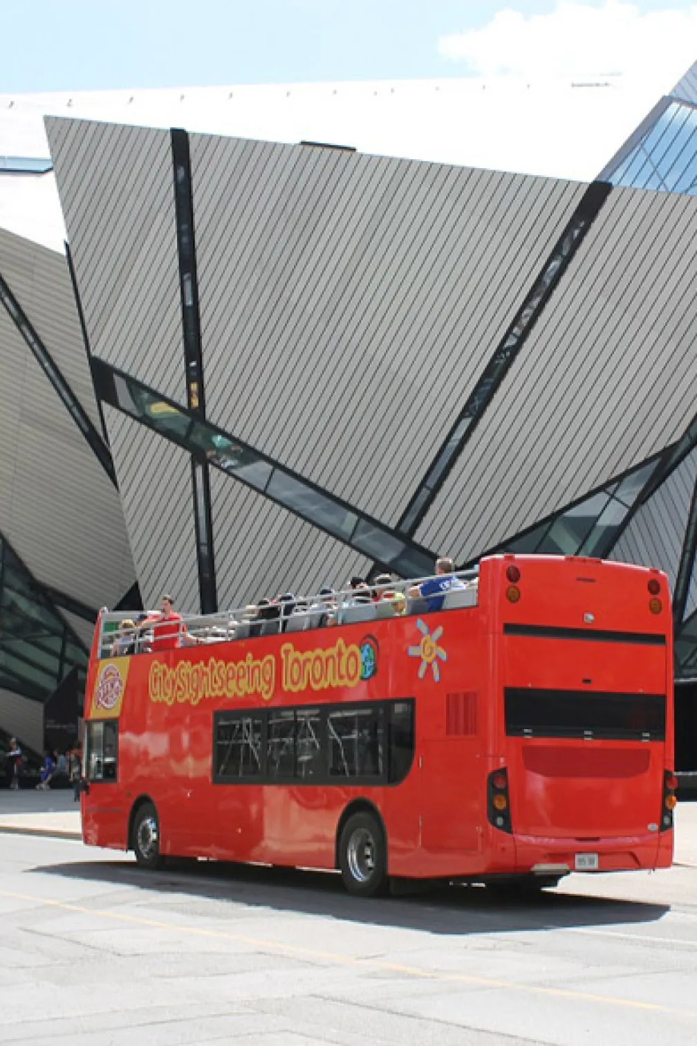 Double-decker bus passing by the Royal Ontario Museum.
