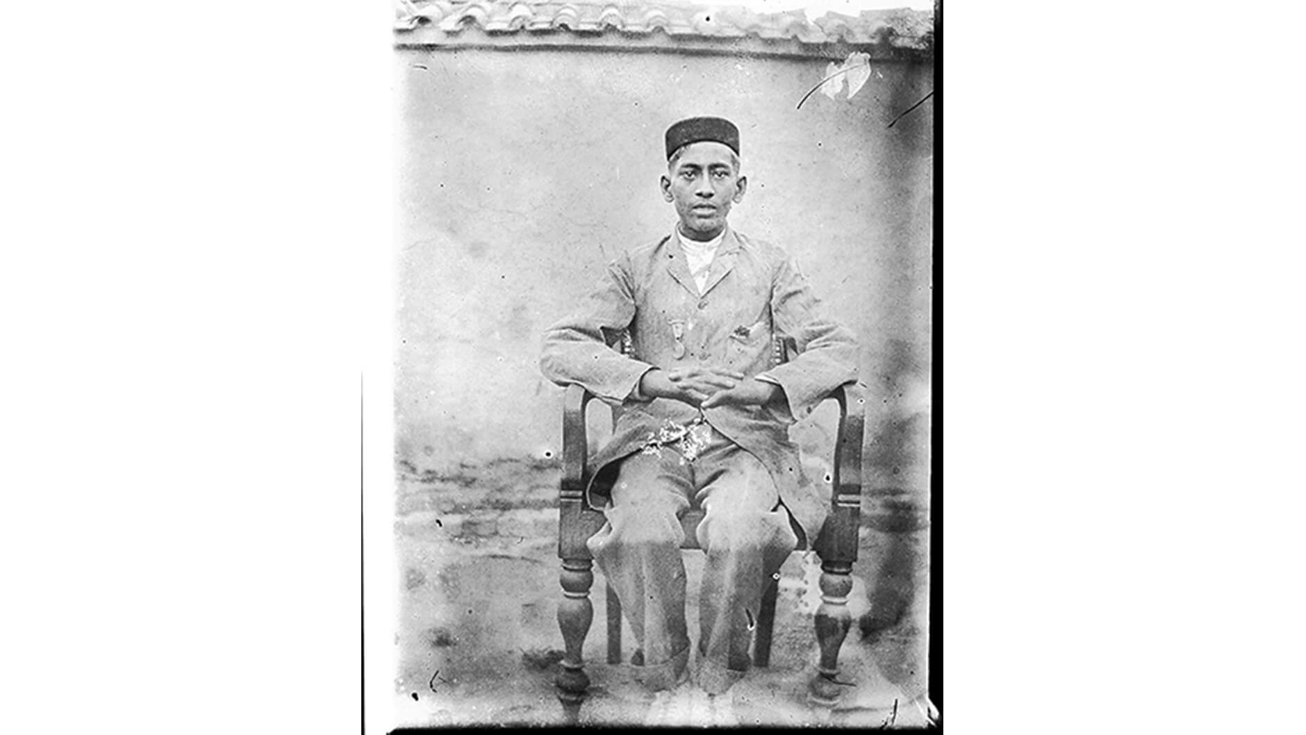 Portrait assis d'un jeune homme avec une médaille.