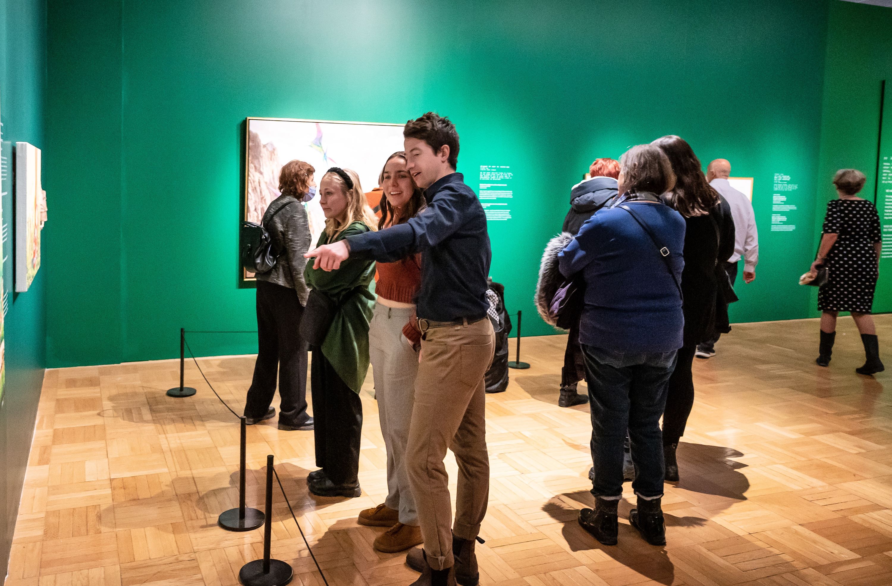 A young couple smile whiling looking at a picture the man is pointing at.