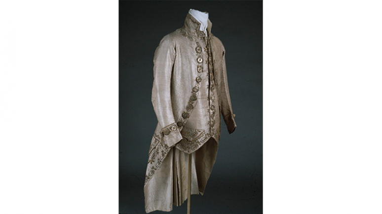 Costume 3 pièces pour homme. Angleterre. 1770-1779. Droguet de soie à trame de filé argenté et motif de flushing-warp brun, brodé de fils métalliques enroulés (lingots d'or), de paillettes d'or et d'argent, de feuilles d'argent et de pâte de verre. 909.33.4.A-C.