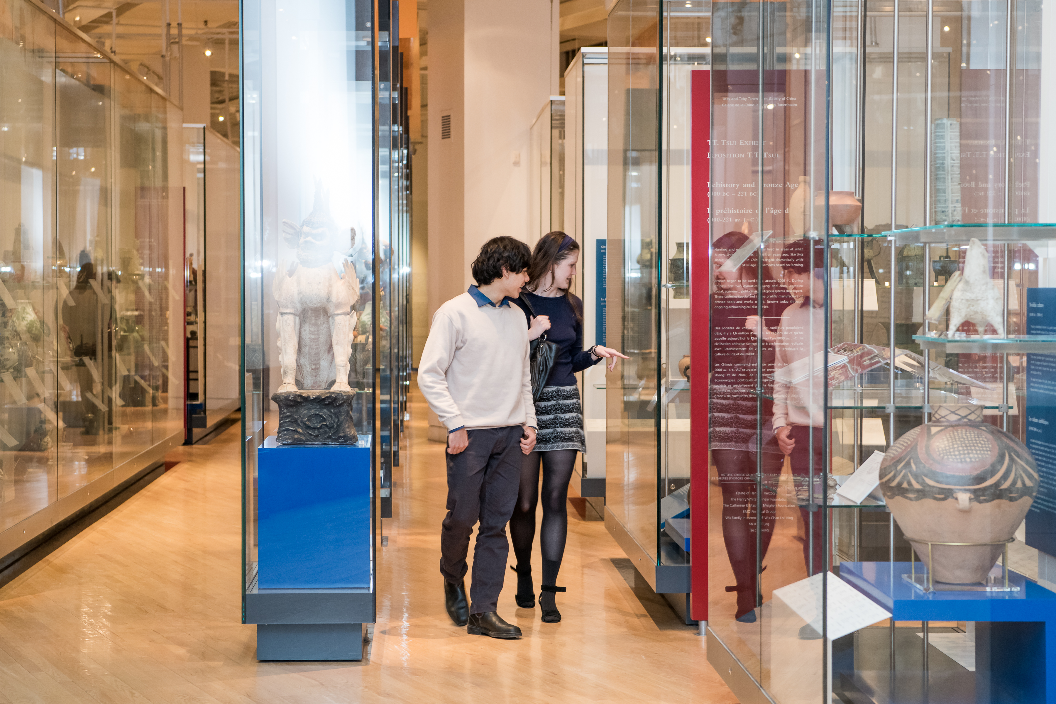 A young couple walk through the China gallery looking at objects 