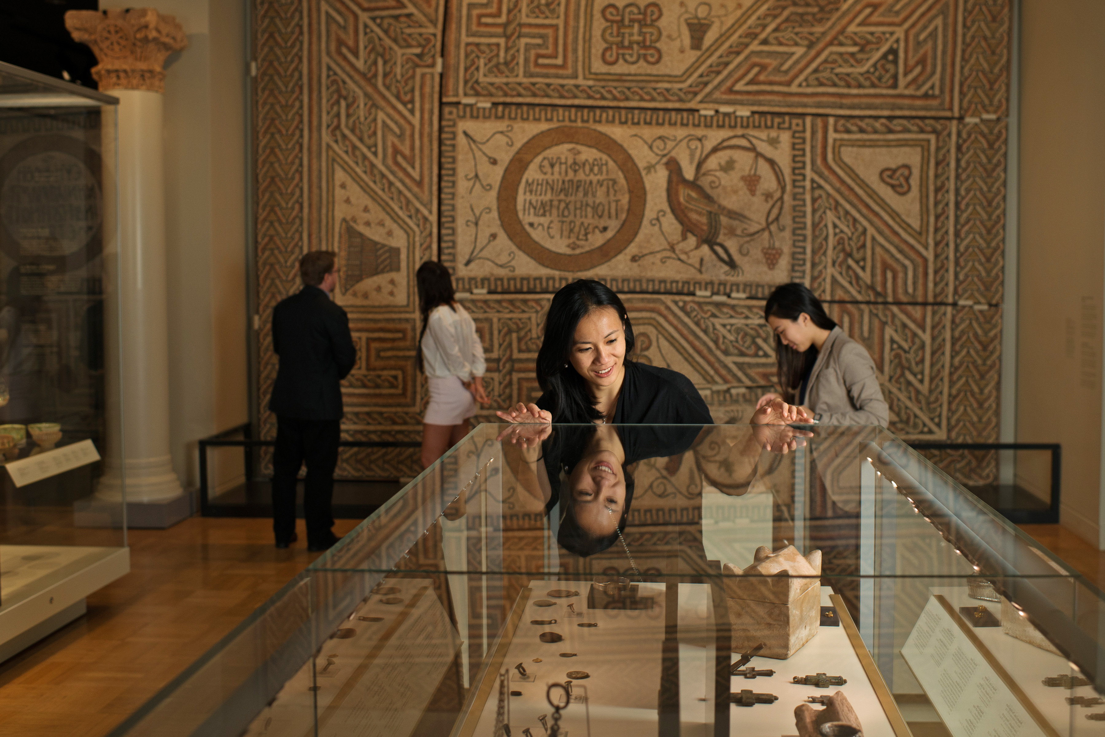 Visitor looking at artifacts in encased glass