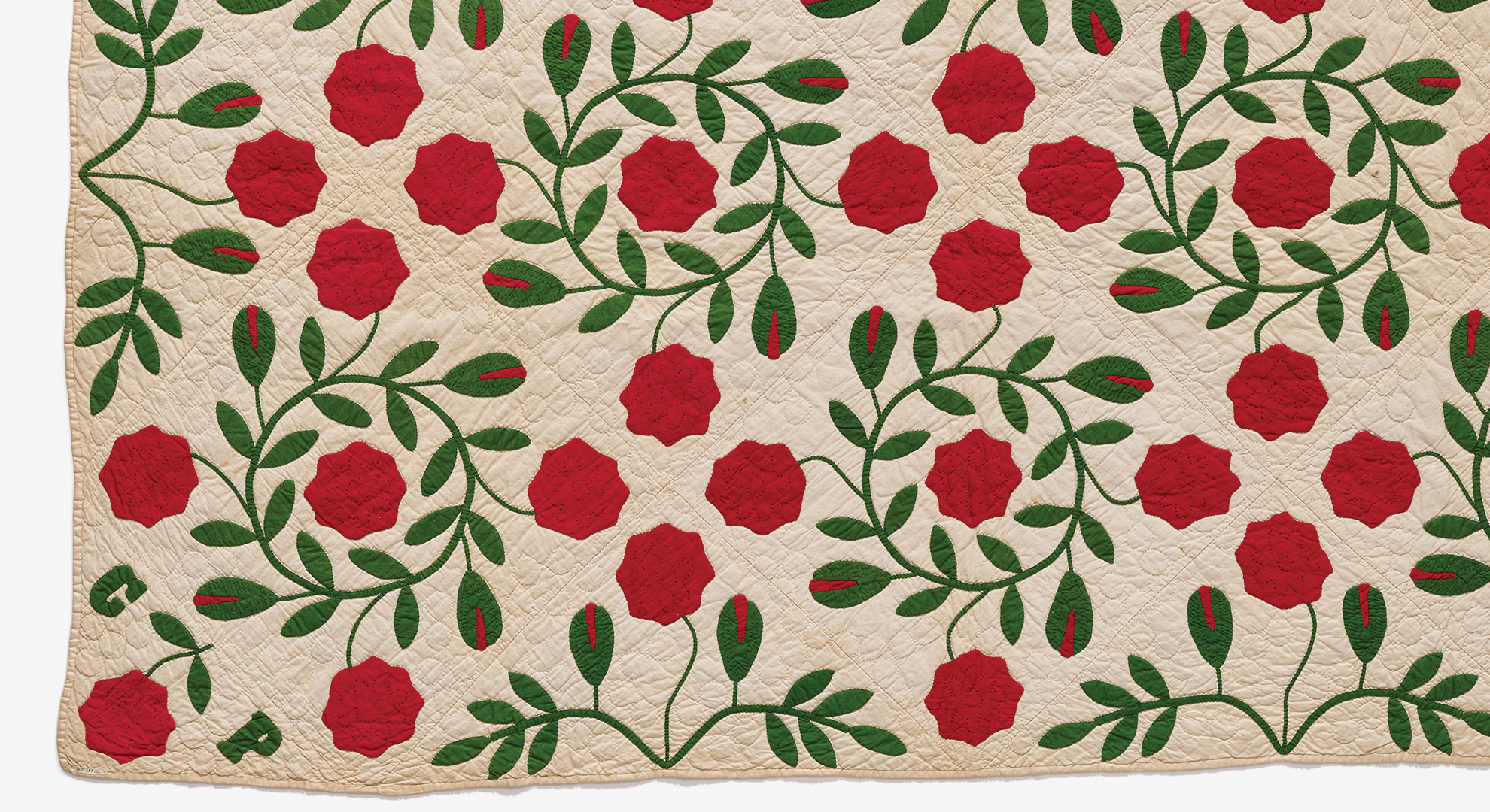  A beautifully crafted red rose quilt adorned with intricate green leaves, showcasing vibrant colors and elegant design.