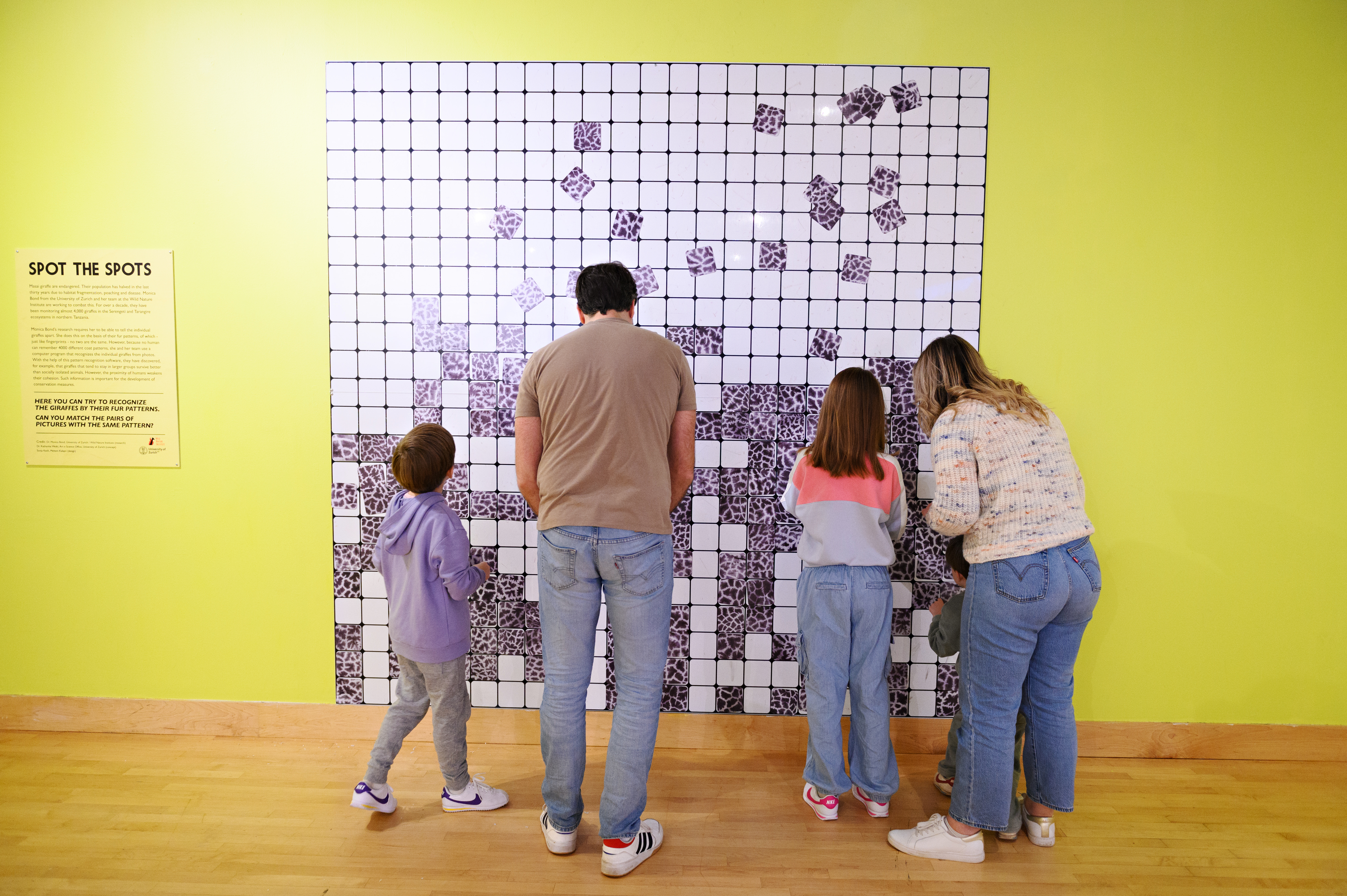 Family enjoying Spot the Spots wall at THEMUSEUM