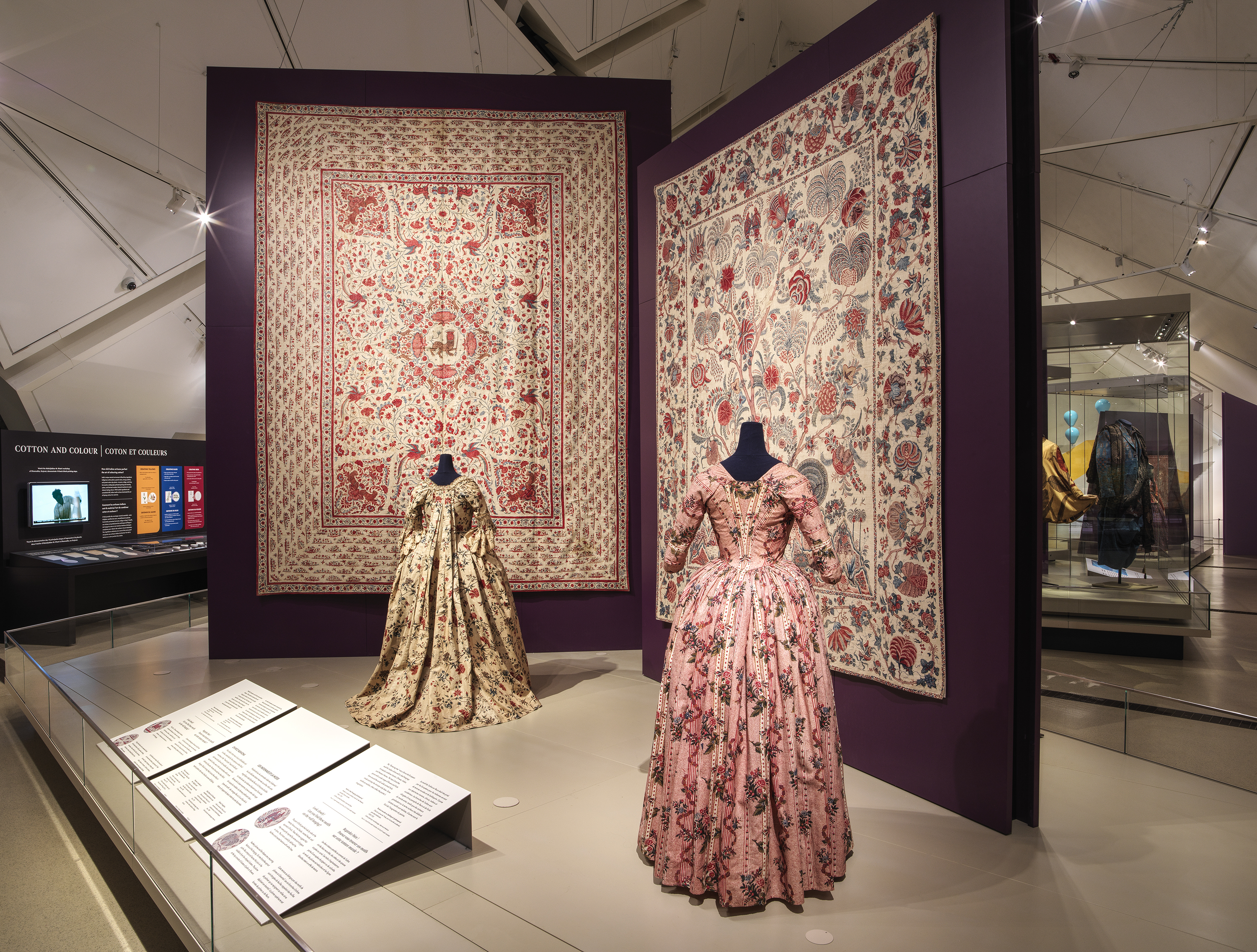 A display case featuring diverse clothing pieces and a book, illustrating a blend of style and reading material.