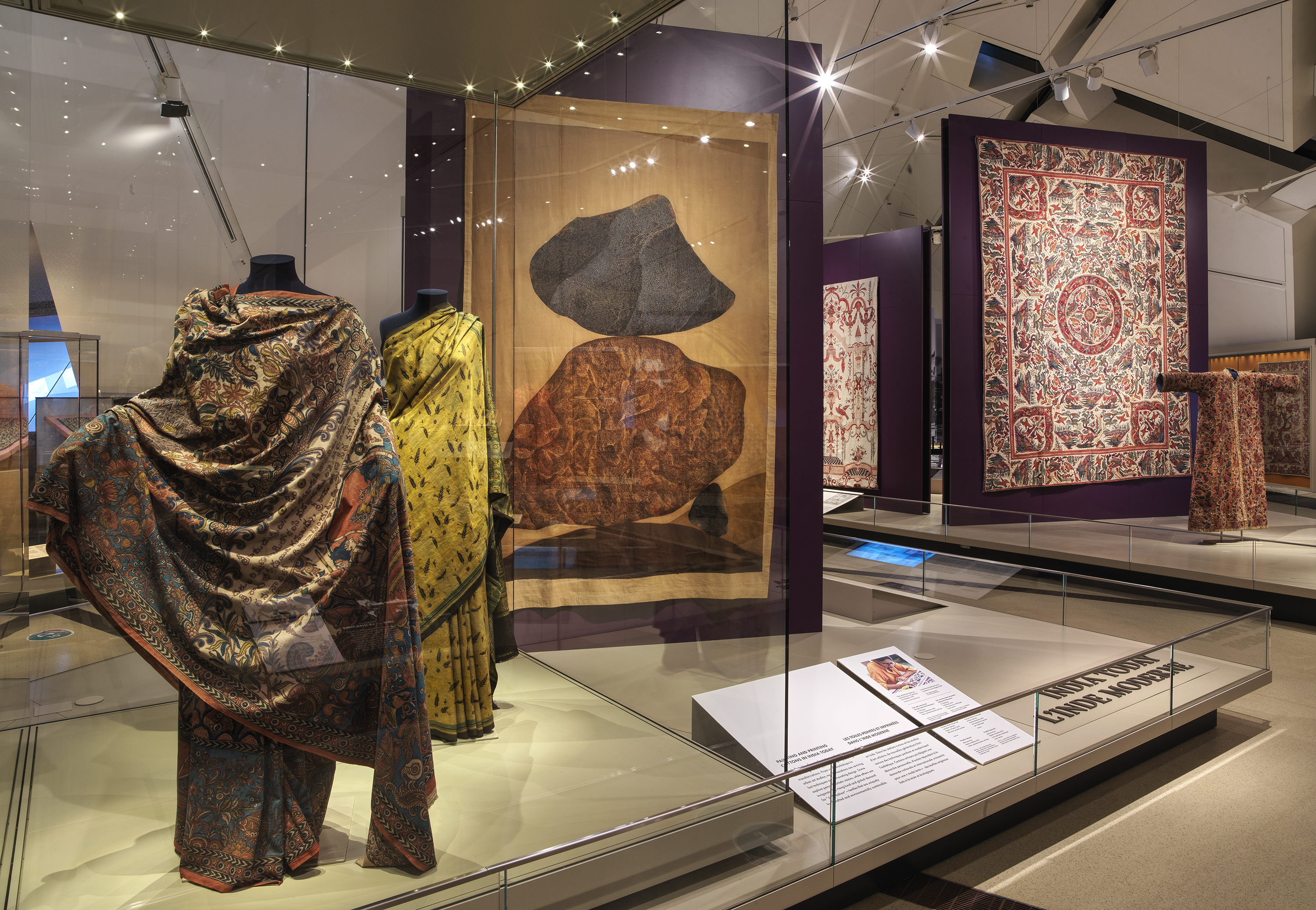 A display case featuring diverse clothing pieces and a book, illustrating a blend of style and reading material.