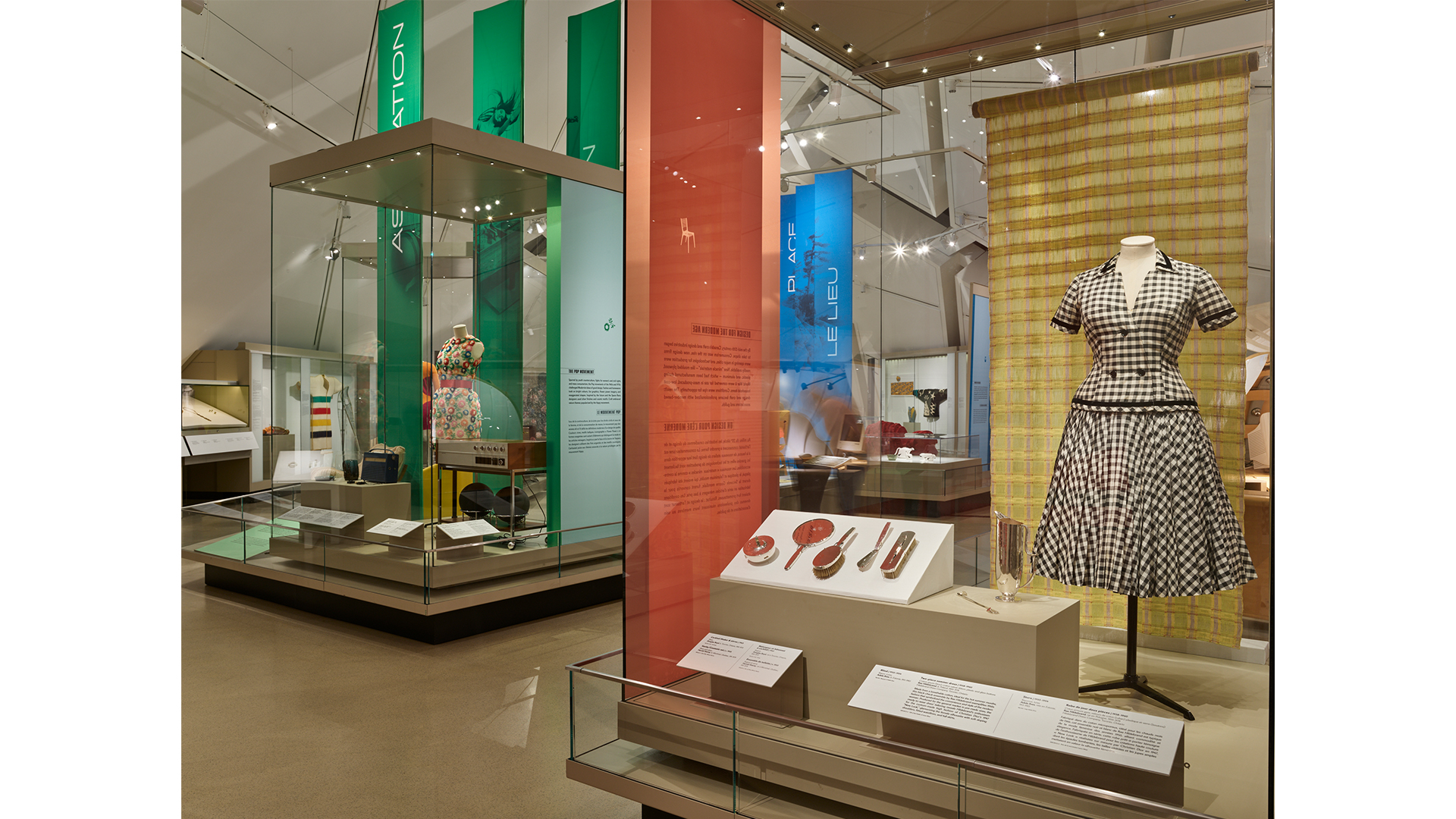 A display case showcasing an elegant dress alongside various complementary items, highlighting fashion and design.