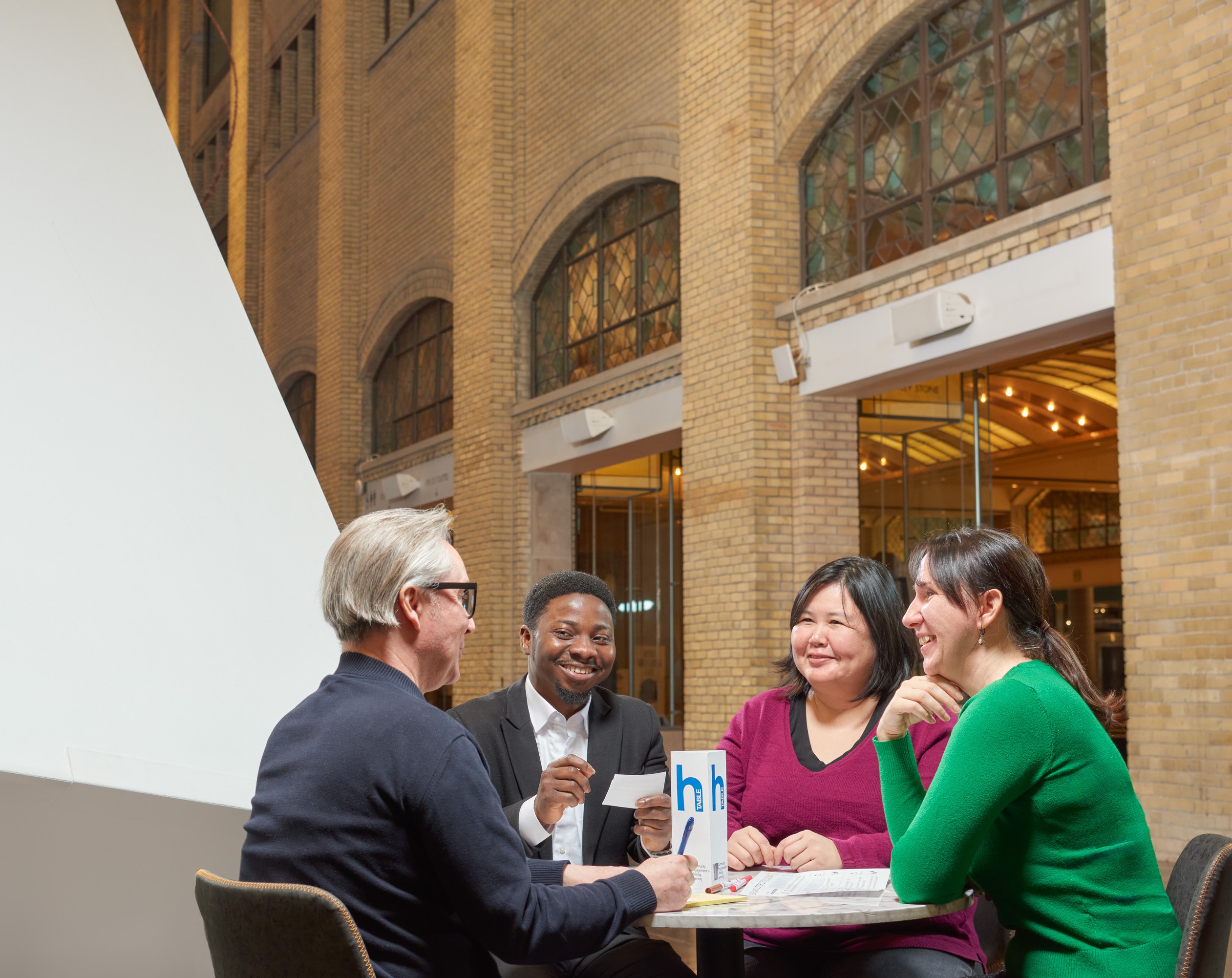 four people sitting at a table, having a fun conversation at the Royal Ontario Museum