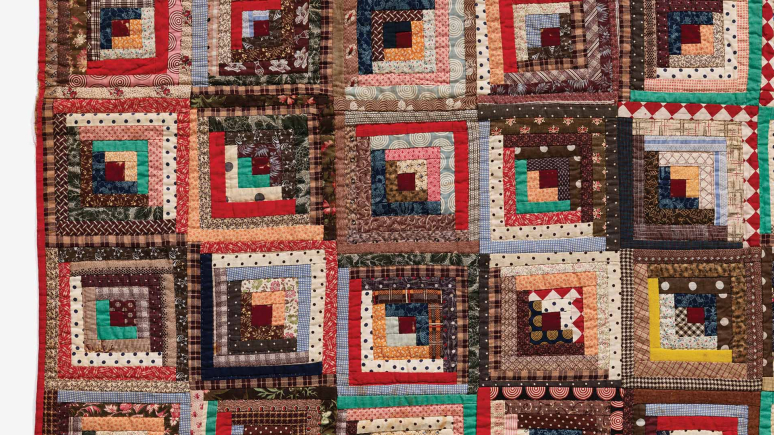 A vibrant quilt featuring an array of colorful squares, showcasing a patchwork of diverse patterns and hues.