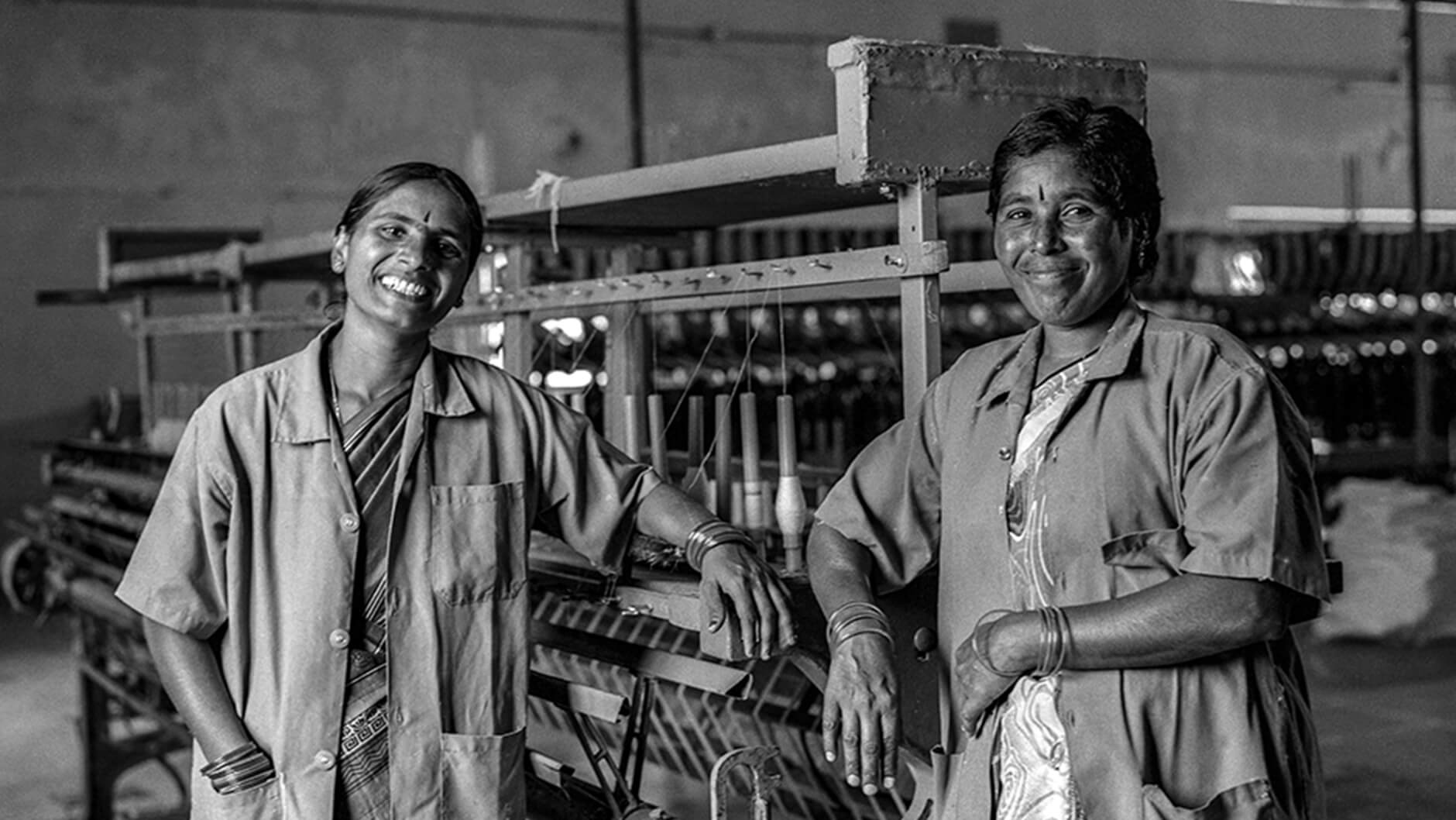 Deux artisans indiens devant une machine de fabrication de textiles.