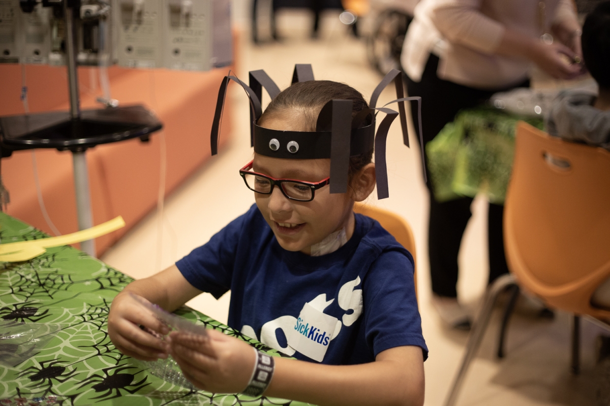 A child a the Hospital for Sick Children engages in a spider craft.