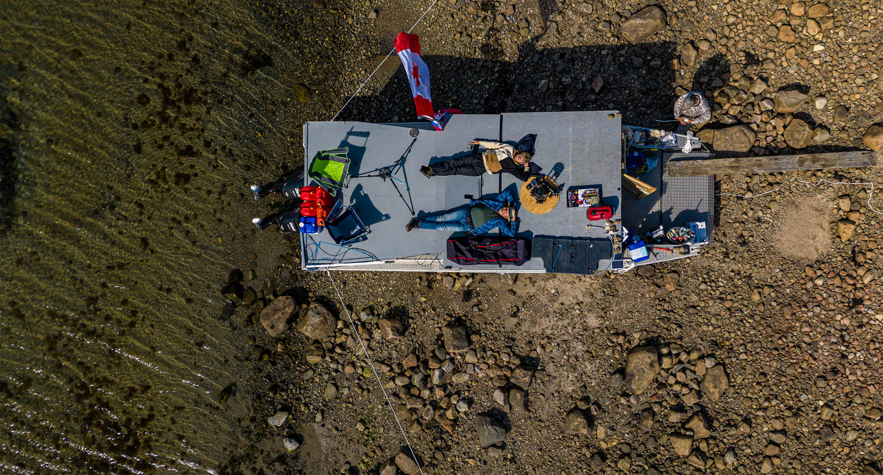 Two people relaxing on the roof of their camp.