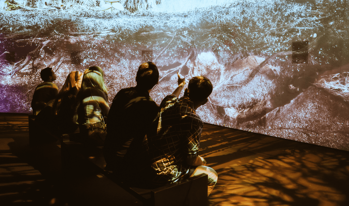 group of people sitting and looking at immersive screens
