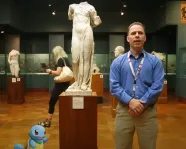 a man and a cartoon turtle stand in front of a statue of Aphrodite