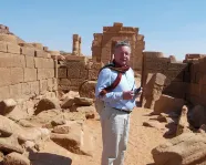 Dr. Krzysztof Grzymski in front of a ruin.
