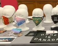 An array of mannequins on a table wearing face masks.