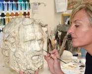 Laura Lipcei painting a Greek statue.