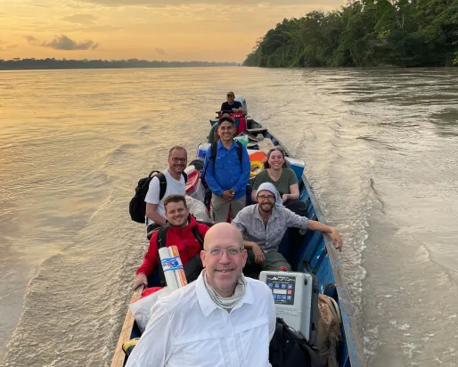 Alors que le soleil se couche derrière eux, le Dr Nathan K. Lujan et son équipe descendent le Rio Napo en bateau, chargés d'une multitude de fournitures.