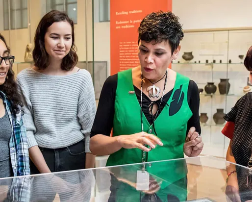 J'net AyAyQwaYakSheelth avec des étudiants regardant une vitrine.
