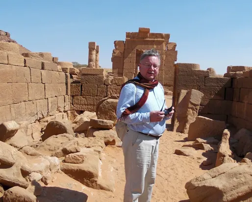 Dr. Krzysztof Grzymski in front of a ruin.
