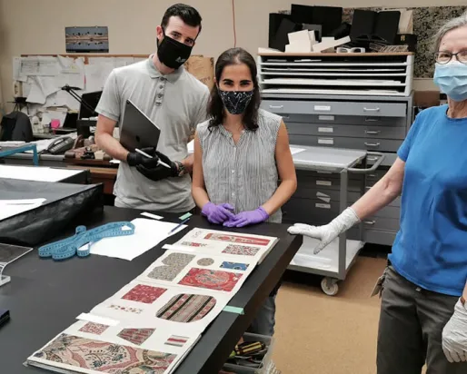 Conservateurs et techniciens du ROM travaillant sur le contenu de l'exposition Cloth the Changed the World.
