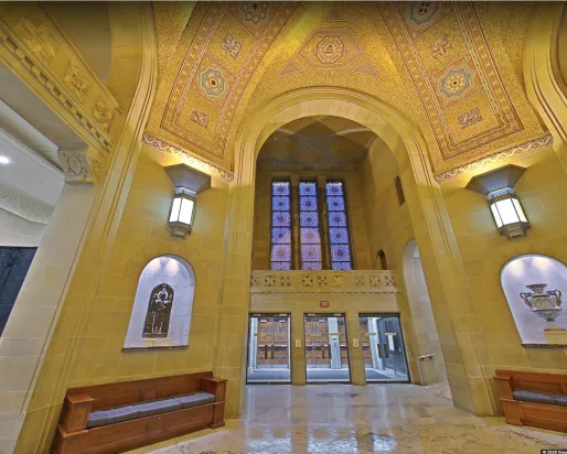 A set of doors beneath a golden mosaic archway
