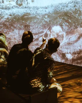 group of people sitting and looking at immersive screens
