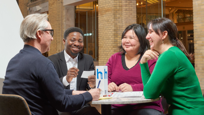 Four people having a conversation around a table