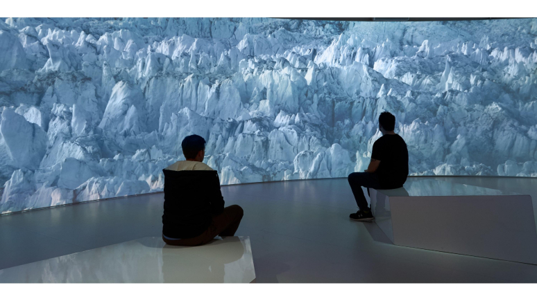 two people sitting looking at a screen with polar ice caps