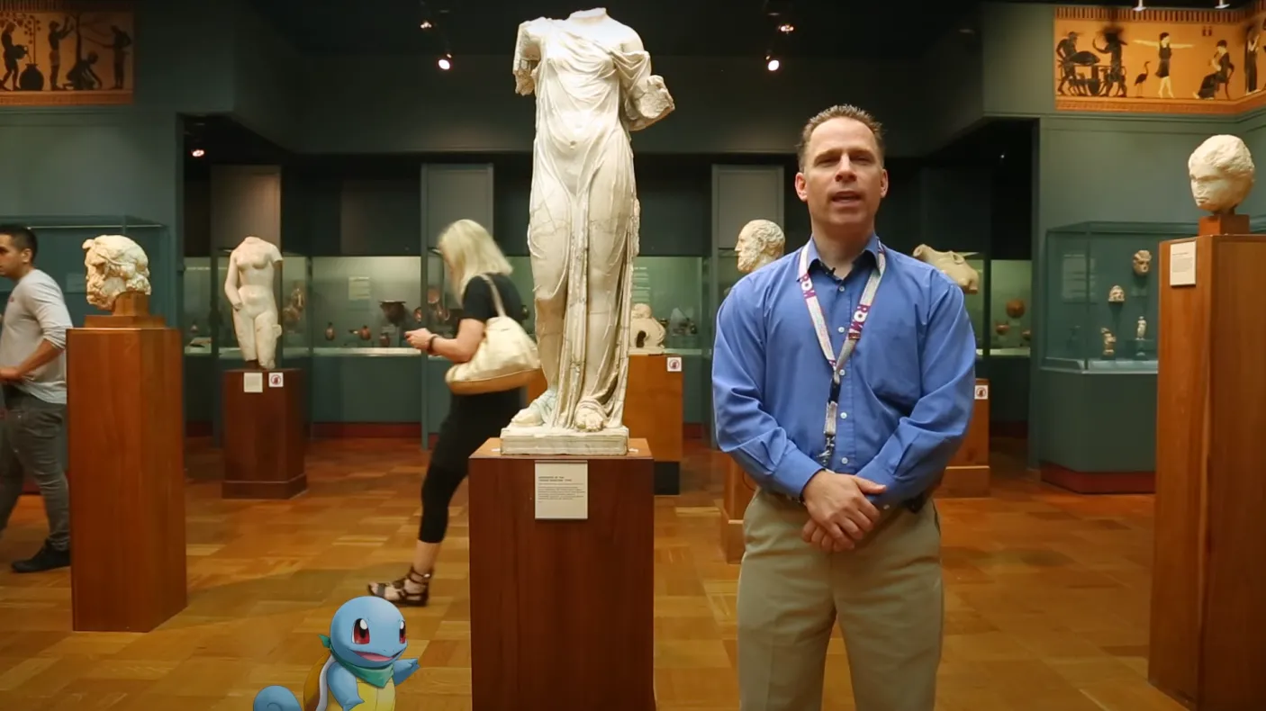 a man and a cartoon turtle stand in front of a statue of Aphrodite