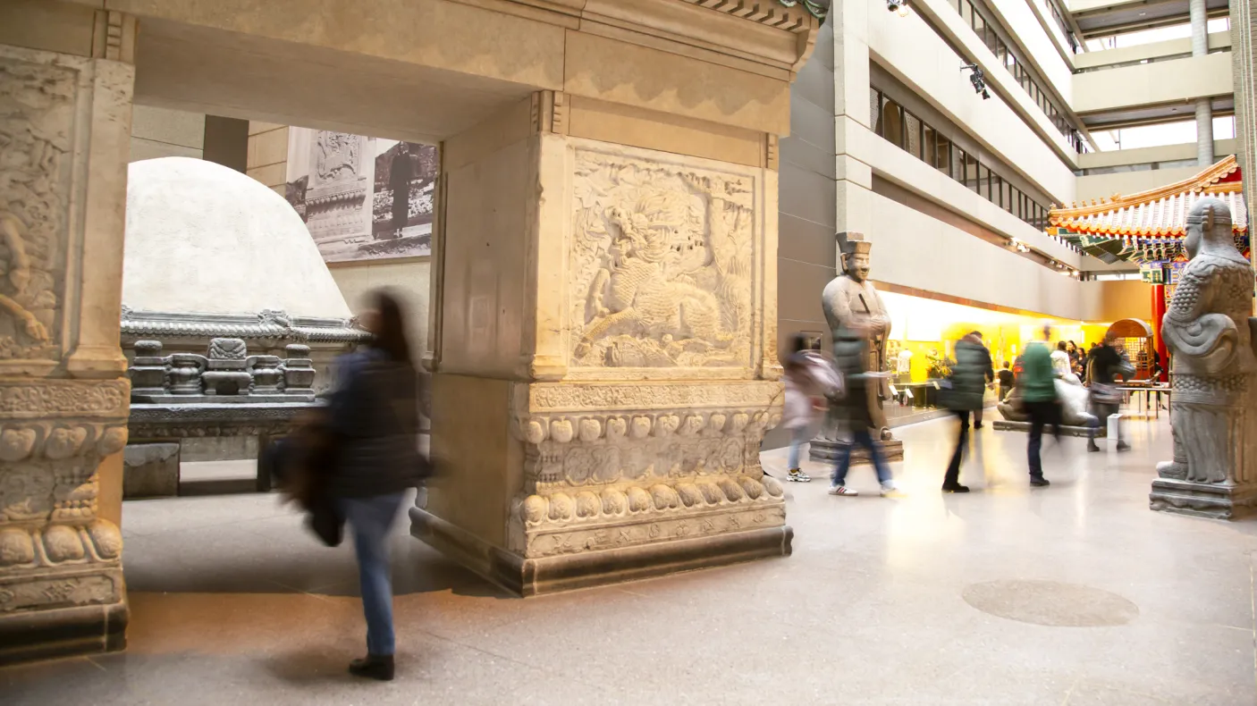 Gallery of Chinese Architecture People walk through a gallery with a large entry gate