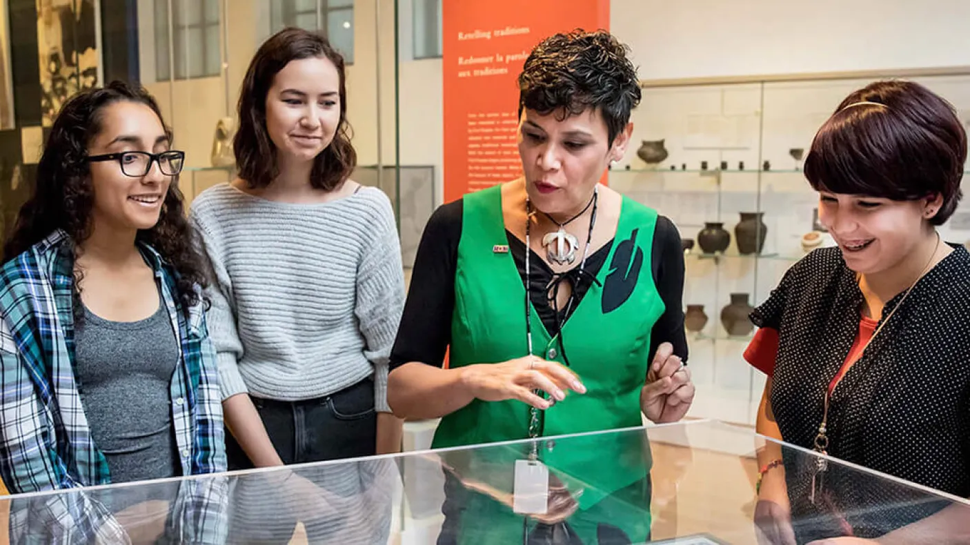 J’net AyAyQwaYakSheelth with students looking at a display case.
