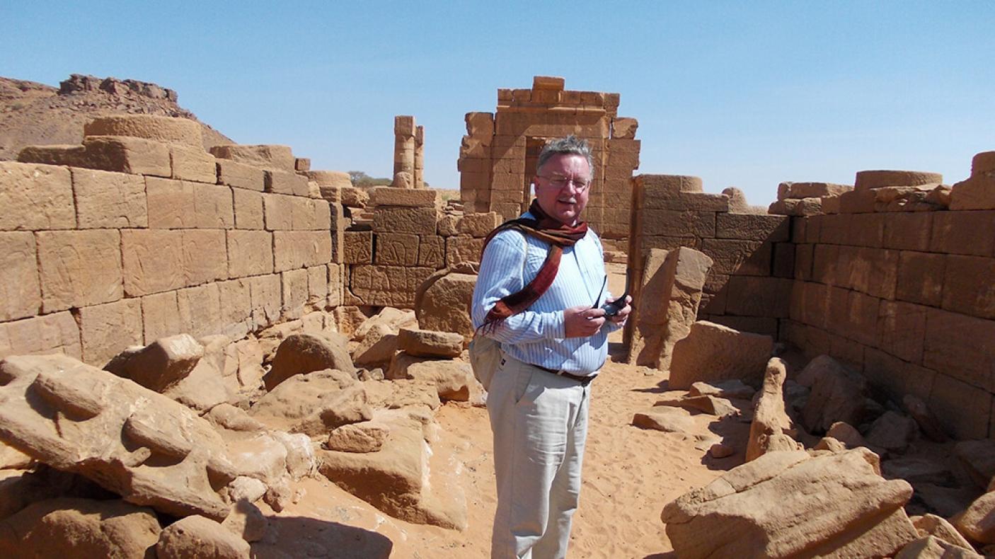 Dr. Krzysztof Grzymski in front of a ruin.
