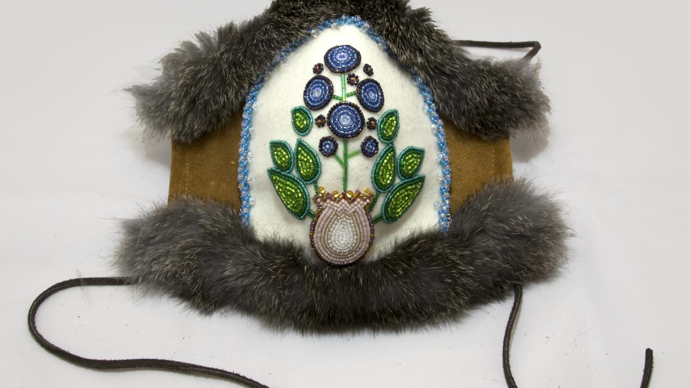 A mask created with beeds in the shape of a blue berry
