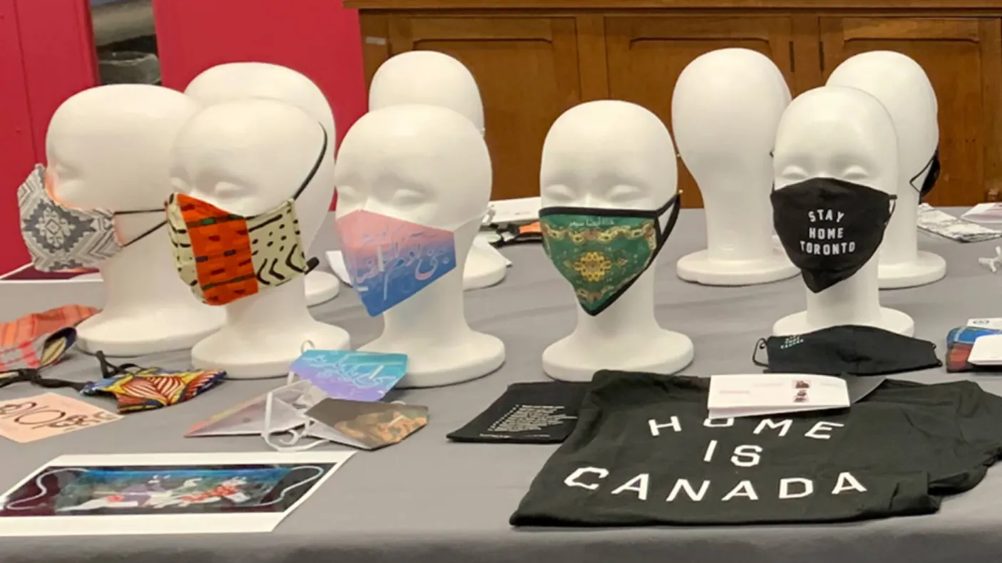 An array of mannequins on a table wearing face masks.