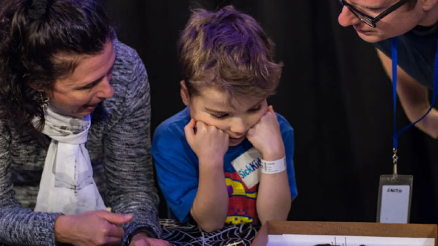 Photo by Mark Bernards @markbernards3
 A child examines a spider specimen with adults