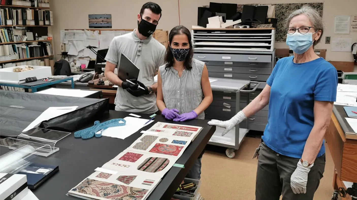 Conservateurs et techniciens du ROM travaillant sur le contenu de l'exposition Cloth the Changed the World.
