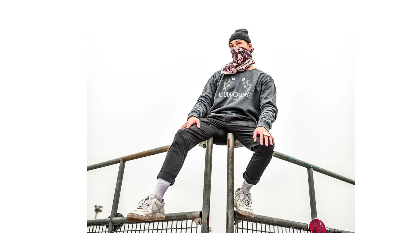 Masked person sitting on bleachers.