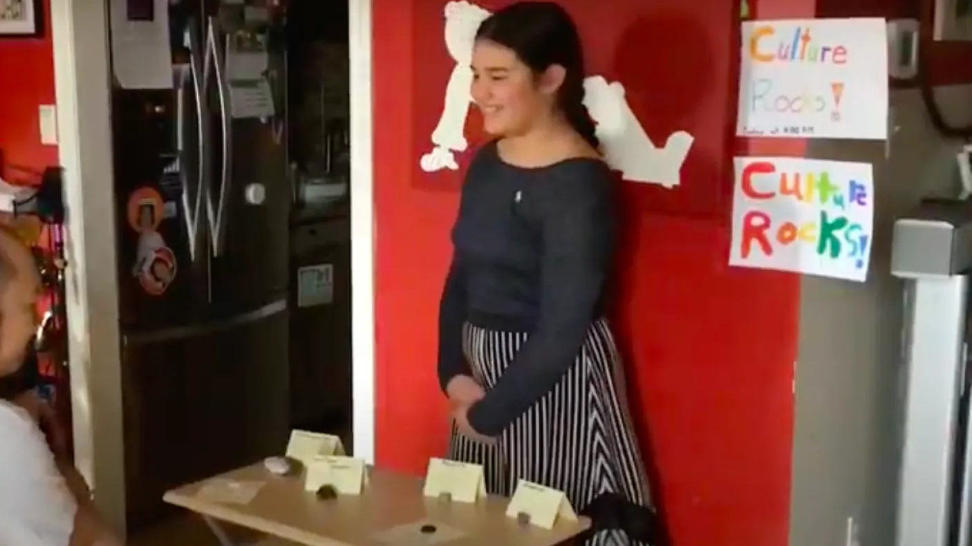 Une jeune fille montre son musée personnel à sa famille.
