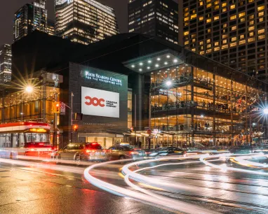 L'extérieur du Four Seasons Centre la nuit, le logo de la compagnie d'opéra canadienne est visible sur l'écran à l'extérieur de la salle.