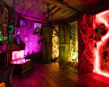 A mysterious room filled with curious objects and lit in vibrant colours.