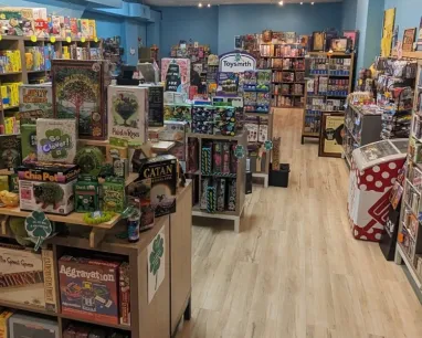 A store with multiple tables, all jam packed with various board and tabletop games.