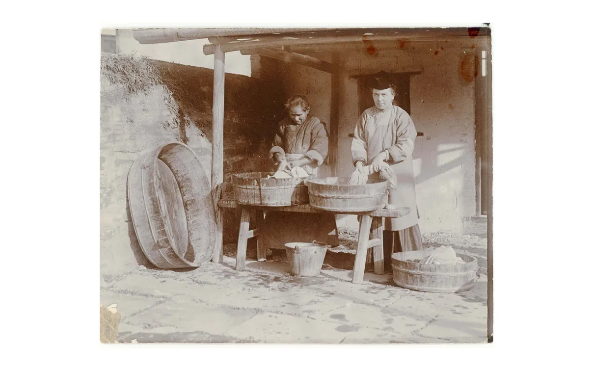 A missionary woman and a Chinese woman washing clothes.