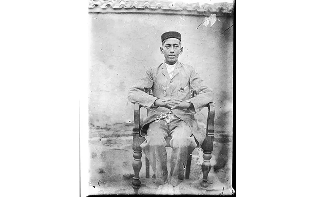 Portrait assis d'un jeune homme avec une médaille.