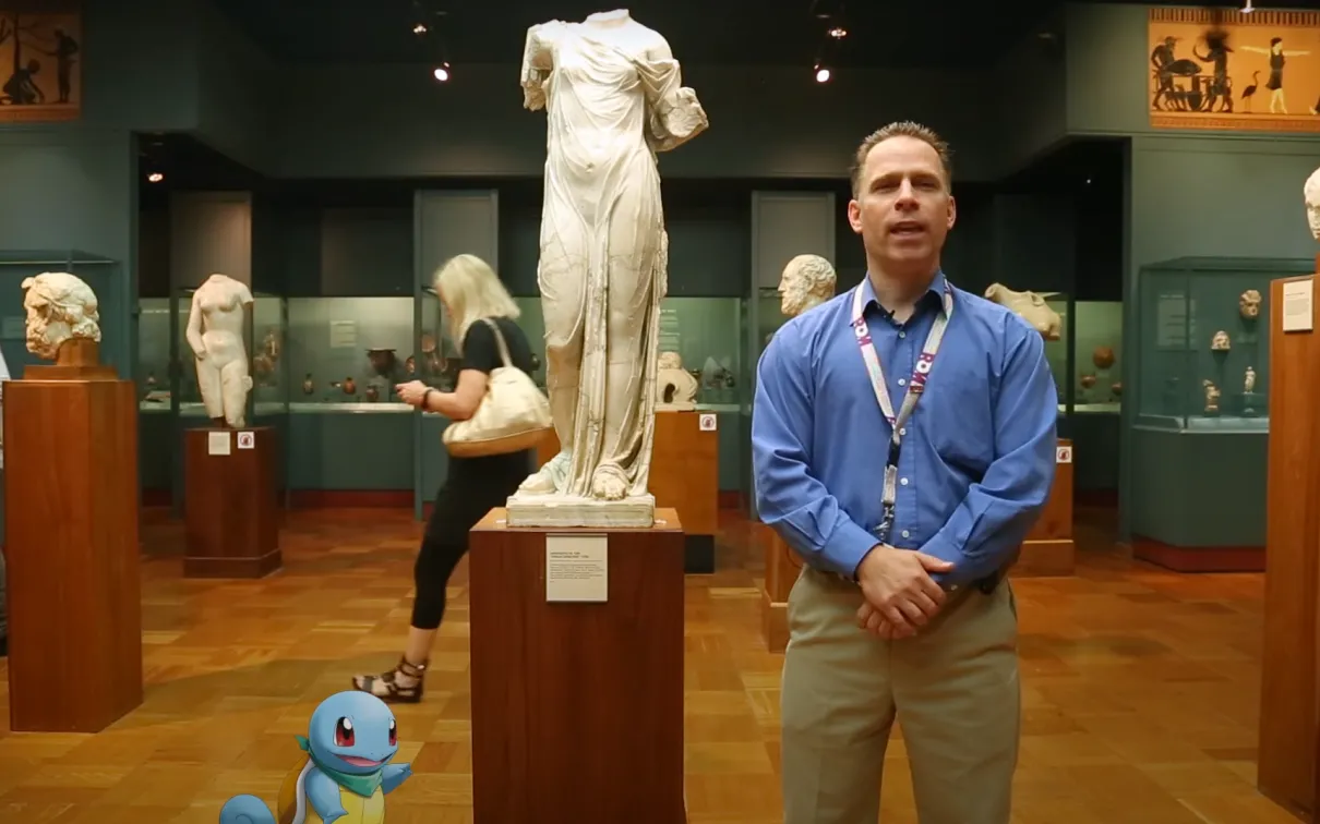 a man and a cartoon turtle stand in front of a statue of Aphrodite