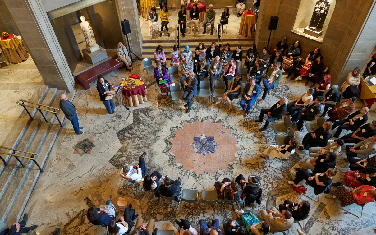 Indigenous Voices Presentation attendees in a large circle listening to a presentation.